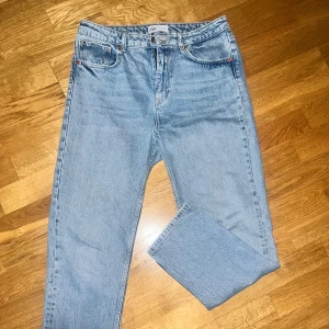 Ljusblå jeans från Zara - Säljer ett par ljusblå jeans från Zara i bra skick. De har en klassisk femficksdesign och är tillverkade i denim. Perfekta för vardagsbruk och kan matchas med nästan vad som helst. Passformen är straight och de har en midwaist.