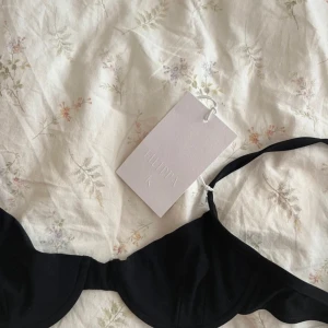 Svart bikiniöverdel från Filippa K - Säljer en stilren svart bikiniöverdel från Filippa K i storlek XS. Den är i nytt skick och har en enkel design med justerbara axelband. Perfekt för en dag på stranden eller vid poolen. Materialet är mjukt och bekvämt, vilket gör den idealisk för sommarens alla badäventyr. 🖤