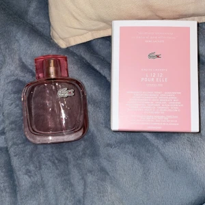 Lacoste L.12.12 Pour Elle Sparkling Parfym - Säljer en elegant och feminin parfym från Lacoste, L.12.12 Pour Elle Sparkling. Flaskan är stilren med en rosa ton och det ikoniska Lacoste-loggan. Perfekt för den som vill ha en fräsch och sprudlande doft. Kommer i originalförpackning. Det är ca 60 ml kvar i 90 ml flaskan skulle jag gissa, 