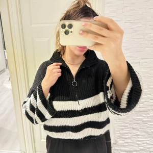 Svart och vit randig stickad tröja - Säljer en supermysig svart och vit randig stickad tröja med dragkedja i halsen. Den är croppad och har långa ärmar, perfekt för en chill dag eller en cool outfit. Tröjan är i bra skick och passar perfekt till höst och vår. 🖤🤍 Passar s/m/l storlek