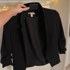Svart kavaj  - Säljer en stilren svart kavaj  i mycket bra skick. Den har en klassisk design med trekvartsärmar och en öppen front. Perfekt för både vardag och fest! 🖤 storlek XS Pris 150:- 