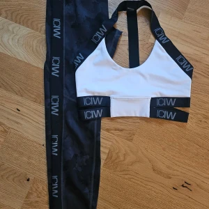 Träningsset från ICIW - Säljer en supersnygg vit sporttopp från ICIW i storlek S. Tillsammans med ett par tights i samma storlek, med ett fint camomönster i svart/grått. Toppen har svarta elastiska band med logotypen ICIW. Endast använt ett fåtal ggr.