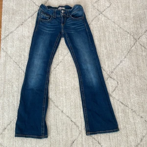 Blå jeans från Gina Tricot - Snygga blå jeans från Gina Tricot med bootcut-stil. De har klassisk femficksdesign och en bekväm passform. Perfekta för en avslappnad look.