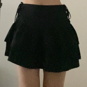 Svart kjol med snörning - Gulligt svart kortkjol med snörningsdetaljer på sidorna. Jag tycker att det kmr passa size 34 pga snörningdetaljer. 