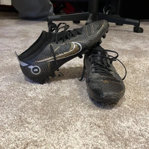 Nike fotbolls skor Flyknit - Snygga svarta fotbollsskor med snörning och mönstrade detaljer i guld och silver. Skorna har dobbar för bra grepp på planen och en stilren design. Nike skor mycket bra skick nypris ca 1600