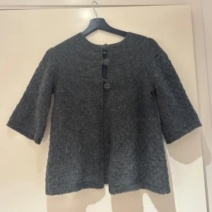 Grå kofta med knappar - Säljer en mysig grå kofta med trekvartsärm och dekorativa knappar framtill. Perfekt för kyligare dagar och ger en stilren look. Passar bra över en enkel topp eller blus. Finns ett litet hål upptill men inget som syns och lätt att sy ihop!❣️