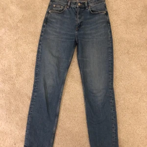 Blå jeans från Arket - Snygga blå jeans från Arket i modellen Jade Cropped. Tillverkade i stretchig denim med en medelhög midja och avsmalnande, croppade ben. Perfekt för en stilren look. Nypris 790