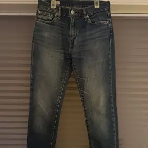 Säljer ett par snygga Levi's Premium jeans i blå denim. De har en klassisk femficksdesign och knappgylf. Jeansen är i storlek 30/32 