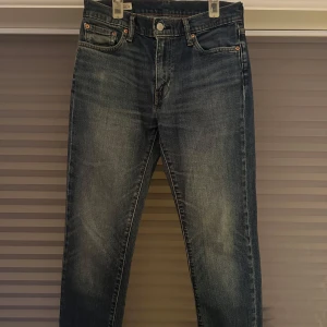 Levi's Premium Jeans - Säljer ett par snygga Levi's Premium jeans i blå denim. De har en klassisk femficksdesign och knappgylf. Jeansen är i storlek 30/32 