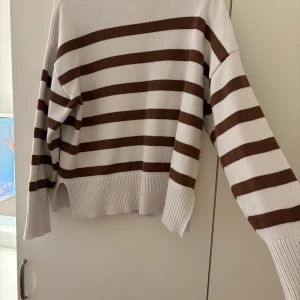 Randig stickad tröja i beige och brun - Säljer en supermysig stickad tröja med breda bruna och beige ränder. Säljer då jag inte har någon användning för den. 
