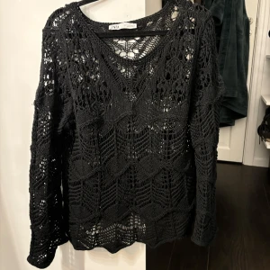 Svart stickad tröja från Zara - Säljer en svart stickad tröja från Zara med ett snyggt hålmönster. Tröjan har långa ärmar och en rund halsringning! Storlek M och inga defekter🌟🌟