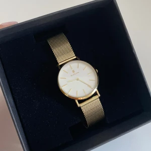 Guld Klocka  - Black oak klocka från UR&PENN, knappt använd, legat i sin box de senaste 2 åren. Inga repor eller skador. Ny pris 698kr, mitt pris 300kr