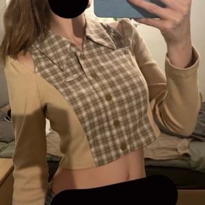 Snygg tröja - Brun beige tröja med rutigt och ribbat tyg. Slightly off shoulder. Bra kvalitet. En knapp som man kan knäppa där uppe. 