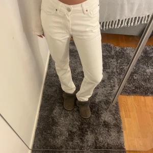 Vita jeans med låg midja - Säljer ett par vita jeans med mellan låg midja och rak passform. De har en klassisk design med dragkedja och knappar. Finns en skada på ena bakfickan men som inte är så synlig. Dom sitter lite för tight på mig och jag brukar variera mellan S och Xs.
