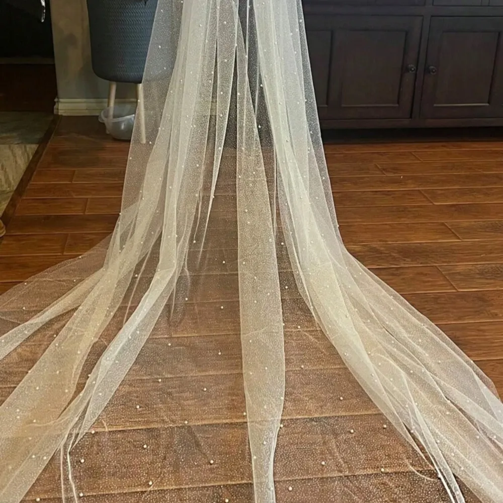 Brand new veil, I ended using something else for my wedding but it is beautiful. The veil is single tiered in cool white with glitter and small pearls. It measures 230cm in length and it is 150 cm wide.. Accessoarer.