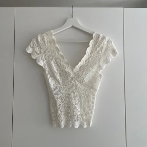 Spetstopp  - Spetstopp i vitt från Stradivarius. I storlek XS men passar även en S då den är strechig. Lite fläckig av smink inuti, men syns knappt (se bild 3).