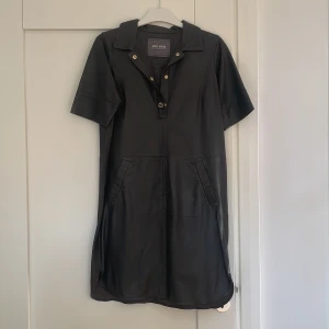 Mos Mosh skinnklänning - Aldrig använd Mos Mosh skinnklänning. Storlek xs. Brunsvart med guldfärgade knappar