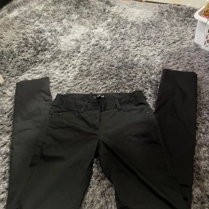 Svarta byxor från H&M - Säljer ett par svarta byxor från H&M i storlek 34. De är stilrena och passar perfekt till både vardag och fest. Byxorna har en klassisk design med dragkedja och knapp framtill.