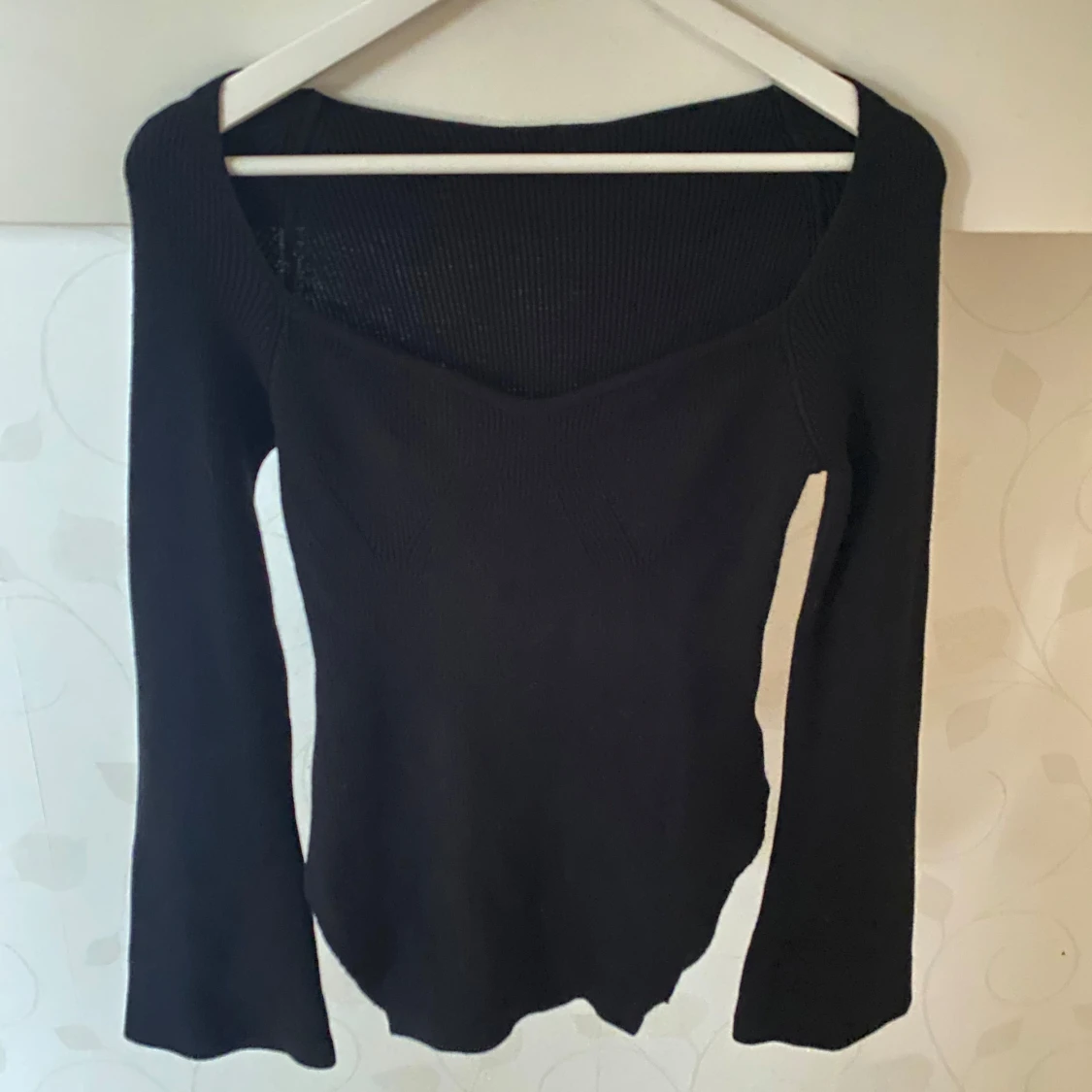 Svart stickad med utsvängda armar