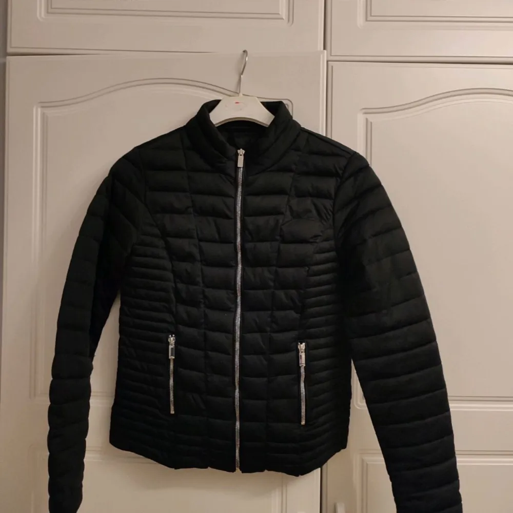 Säljer en snygg svart quiltad jacka med dragkedja fram och två fickor med dragkedjor. Perfekt för höst, vinter och vår, den är både stilren och praktisk. Jackan har långa ärmar och en normal passform. Passar perfekt till vardags eller en utekväll. 🖤. Takit.
