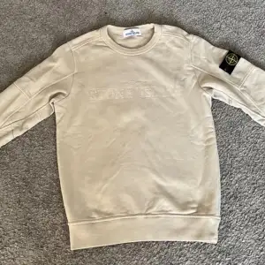 Säjer en snygg beige tröja från Stone Island, den är i nytt skick och endast använd några få gånger. Tröjan är i storlek Junior och passar för folk från 10-12 år gamla. Modellen görs ej längre vilket gör den ännu mer exklusiv😉Nypris var 2000 på NK✅