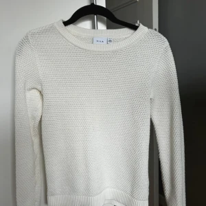 Vit stickad tröja från VILA - Säljer en superfin vit stickad tröja från VILA i storlek XS i nyskick. Perfekt inför hösten och  för kyliga dagar. Tröjan har långa ärmar och en rund halsringning. Passar både till vardags och lite finare tillfällen. 🧶✨