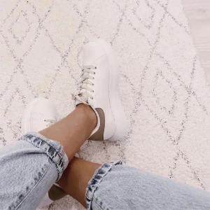 Vita nelly sneakers - Ett par vita sneakers från nelly med beige ”mocka” baktill. Beiga skosnören. Knappt använda då de var lite små när jag köpte dem. Liknar alexander mcqueen sneakers