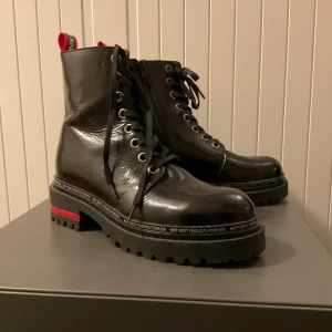 Svarta boots med röd detalj - Säljer ett par svarta boots! Endast använda engång, köpta för 120€  Pris kan diskuteras!
