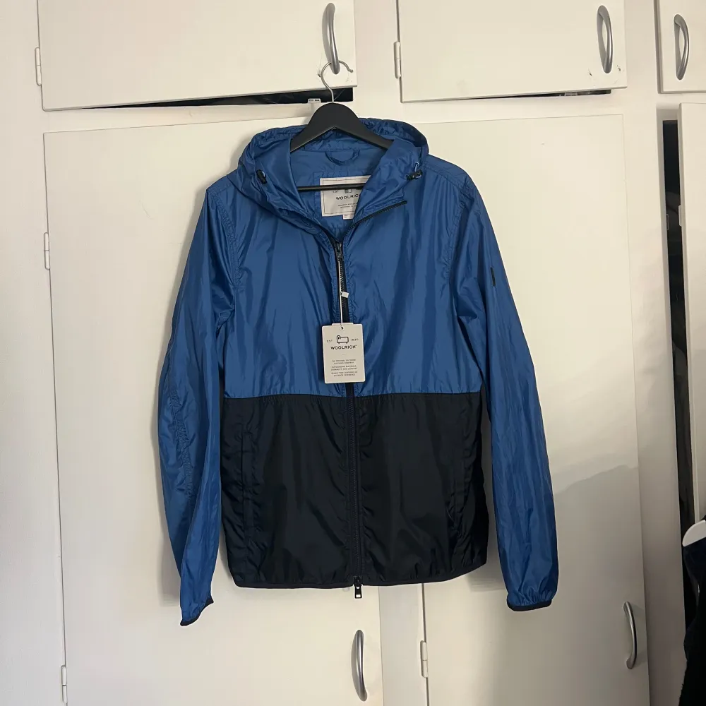 Woolrich Windbreaker i 10/10 skick, aldrig använd med tagsen kvar. Storlek M passar M/S. . Jackor.