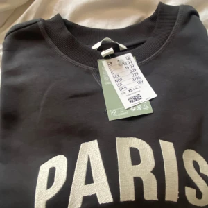 mörk grå sweatshirt  - Säljer en sweatshirt i nyskick med prislappen kvar.  Den har väldigt snygg grå färg 🩷 Dessutom är den väldigt mjuk pågrund av att den är ny ☺️