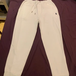 Ralph lauren byxor - Säljer ett par vita mjukisbyxor från Ralph Lauren. De har en bekväm passform med snörning i midjan och den klassiska loggan broderad på sidan. Perfekta för en avslappnad dag hemma eller en snabb tur till affären. Supermjuka och sköna!