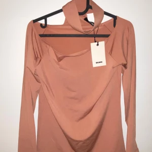 Bikbok beige/rosa topp - Snygg topp med krage och axelbandslös design. Toppen är i en mjuk och bekväm passform. Oanvänd. 