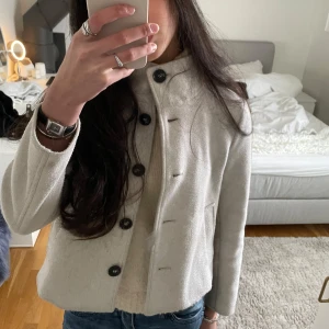 Vit kappa med knappar - Säljer en snygg vit kappa med knappar som är perfekt till både höst och vår. Säljer pga den kom inte till användning, skriv vid frågor❤️🫶