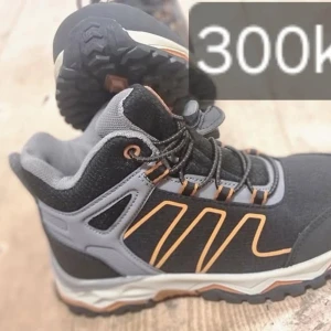 Svarta och grå boots från Urberg - Säljer ett par robusta svarta och grå boots från Urberg med orange detaljer. Skorna har snörning och en slitstark sula, perfekt för utomhusaktiviteter. De är designade för att ge bra stöd och komfort. Oanvända