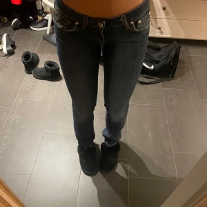 Mörkblå jeans från Just Cavalli - Snygga mörkblå jeans från Just Cavalli med låg midja och tight passform men svänger ut där nere. Jeansen har klassisk femficksdesign och dekorativa nitar vid fickorna. Perfekta för en stilren look.