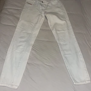  jeans från Diesel - Snygga jeans från Diesel i modellen Livier-Ankle färg mellan vit och ljus blå.Dessa super slim leggings har låg midja och är tillverkade i stretchmaterial för en bekväm passform. Perfekta för en stilren look.
