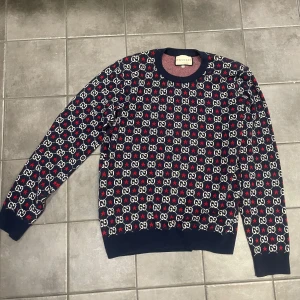 Gucci tröja  - Säljer en snygg och trendig tröja från Gucci i multifärgat mönster med deras ikoniska GG-logga. Tröjan är tillverkad i bomull och har långa ärmar. Perfekt för jul då den är väldigt skön och håller värme bra. Kan gå ner i pris vid snabb affär