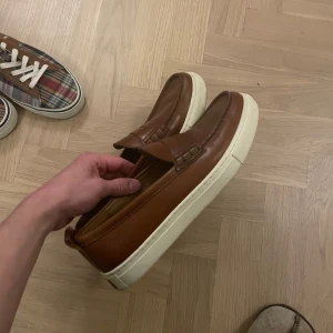 Bruna loafers från Polo Ralph lauren - Snygga bruna loafers från Polo i skinn med en vit sula. Perfekta för en stilren look. Dessa är från en provkollektion så det är inte många som har samma. Skorna är ovanligt bekväma för att vara loafers! Endast använda en gång. Meet up i Stockholm funkar, kan frakta mot betalning🙌🏻