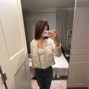 Beige kavaj - Snygg beige kavaj med långärmad design och knappar framtill. Perfekt för en stilren look. Skriv för mer bilder osv 