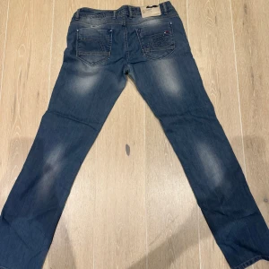 Blå jeans från Hilfiger Denim - Snygga blå jeans från Hilfiger Denim med klassisk femficksdesign och diskret tvätt för en trendig look. Perfekta för en avslappnad stil. Extremt lågmidjade. Passar både S och M beroende på hur du vill att dem ska sitta