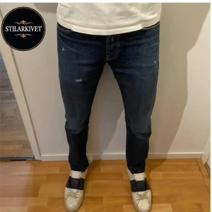 Mörkblå Jeans - Säljer nu mina snygga, mörkblå jeans med slitningar från Jack & Jones. Nypris 1000kr mitt pris 249kr. Jeansen är så gott som helt oanvända då de inte passade mig.