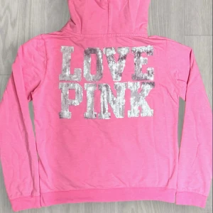 Victoria's Secret set LOVE PINK - En rosa hoodie och matchande byxor från Victoria's Secret🤩 med texten 'LOVE PINK' i glittriga bokstäver💗. Har två små fläckar vid dragkjedjan och en fläck som knappt syns när hoodie är på vid öppning på luvan (se sista bild). Jag har inte lyckats få bort i tvätten. pris kan diskuteras!🫶💞. Hoodie är i storlek L och byxor i storlek XL men skulle säga att dom sitter som S 