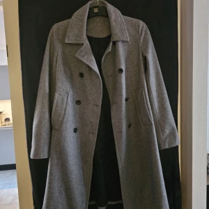 Grå kappa från Mango - Elegant grå kappa från mango. Perfekt för kyligare dagar med sin stilrena design och långa ärmar. Passar utmärkt för både vardag och mer formella tillfällen.skriv om frågor!💗