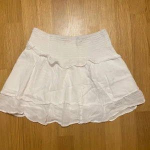Vit kjol från Gina Tricot - Säljer en söt, vit, volang kjol från Gina Tricot. 