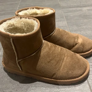 Bruna uggs - Mysiga bruna uggs med mjukt foder, perfekta för kalla dagar. Köpta på lager 157. Använda väldigt få gånger. Pris går att diskutera. Står storlek 40/41. Men passar mig som brukar ha 38/39