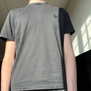 Svart t-shirt från Moncler - Snygg svart t-shirt från Moncler med stort tryck på ryggen. Perfekt för en stilren look. Topp skick, inga defekter. Kvitto o tags tillkommer. Pris 400