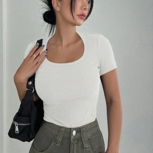 Vit ribbad topp - Snygg vit ribbad topp med korta ärmar och rund halsringning. Perfekt för en stilren look. 