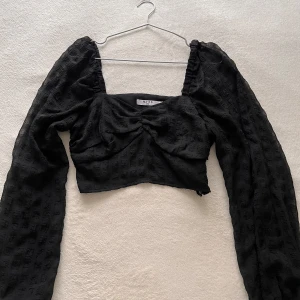 Svart långärmad topp från NA-KD - Snygg svart långärmad topp från NA-KD med en croppad passform. Använd ett fåtal gånger 💕