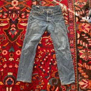 Levis 501 jeans - Snygga blå Levis 501 med klassisk femficksdesign och knappgylf. Perfekta för en avslappnad stil. De har en rak passform och är tillverkade i slitstarkt denim.