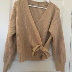 Beige omlottkofta med knyt - Säljer en superfin och mysig beige omlottkofta med knyt framtill❣️lite nopprig, men inget jag tycker syns så mycket. Jag upplever att färgen är lite ljusare i verkligheten. Hör jättegärna av dig om du har några frågor osv💞 